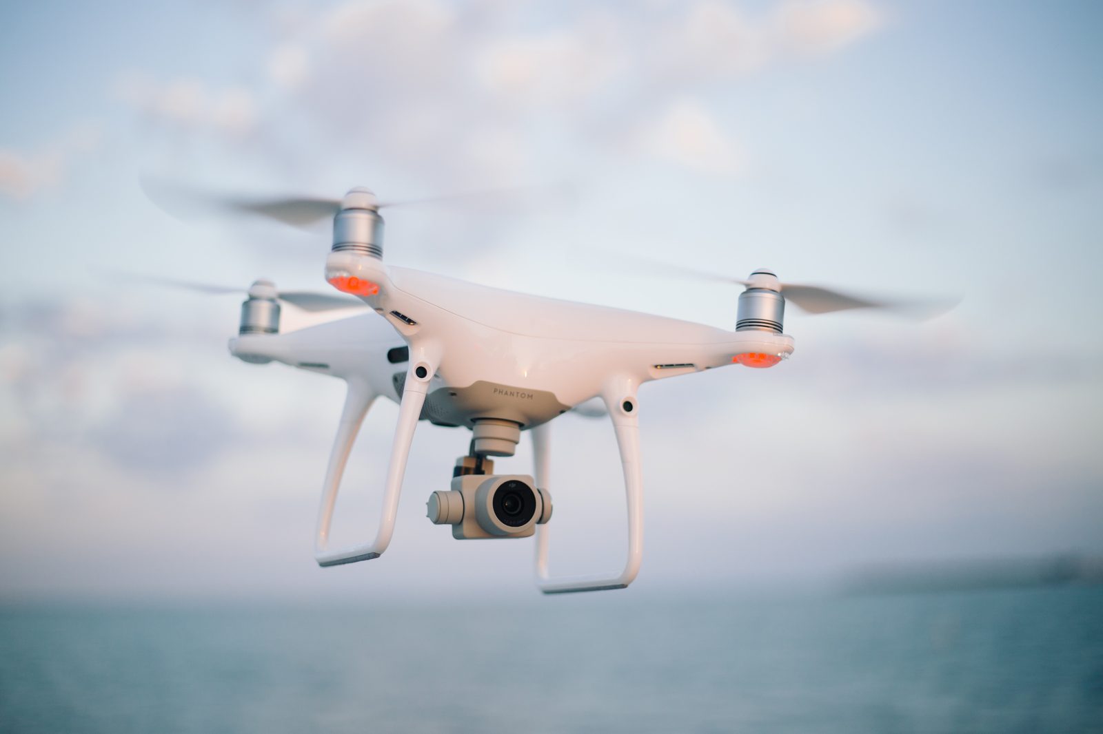 federal-register-drone-tariffs-2026-08-19 A quadcopter camera drone in flight against a clear sky